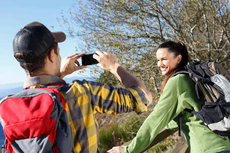 Hikers taking photograph, mountains in background, Montseny, Barcelona, Catalonia, Spain