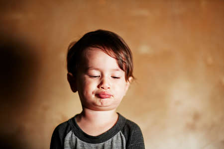 Portrait of cute male toddler pulling facesの写真素材