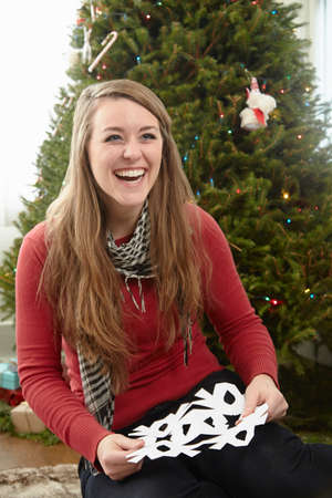 Young woman preparing snowflake decorations at christmasの写真素材