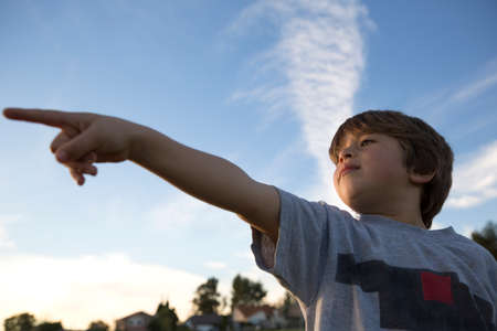 Low angle view of boy pointing finger in park