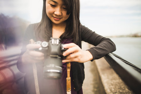 Young woman taking photographs, outdoorsの写真素材