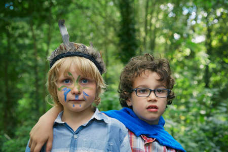 Portrait of two boys in forest with face paintの写真素材