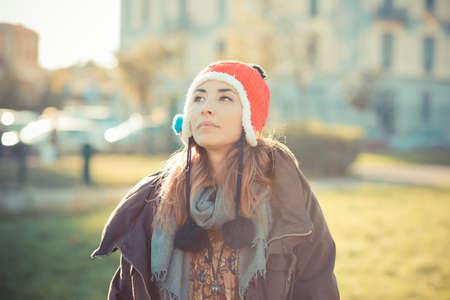 Mid adult woman wearing red pom pom hat in park
