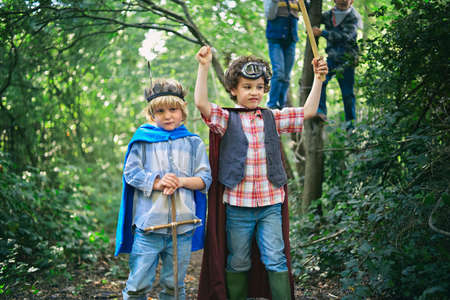 Two boys dressed up and playing in forestの写真素材