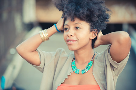 Portrait of beautiful young woman with hands in hairの写真素材