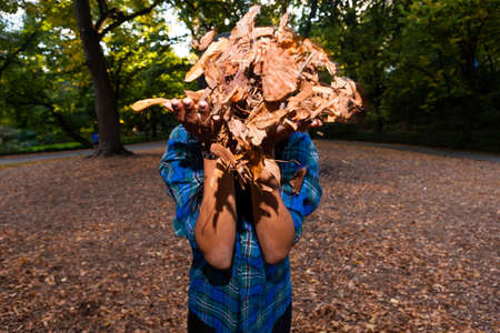 Woman blowing autumn leaves