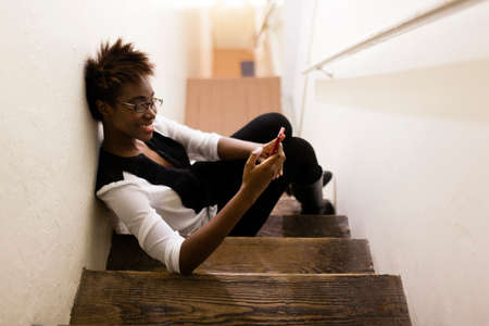 Woman using smartphone on staircaseの写真素材