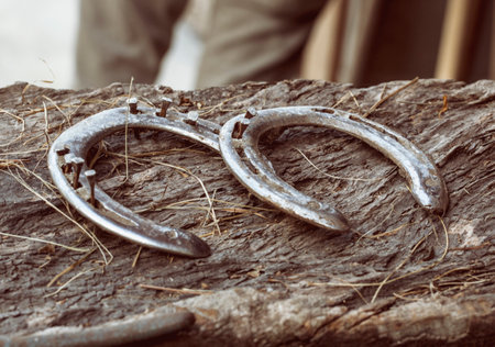 Close up of two worn horse shoes on woodの写真素材