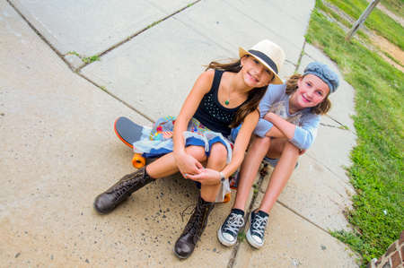 Portrait of girls sitting on skateboardsの写真素材