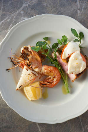 Plate with seafood, herb garnish and lemon sliceの写真素材