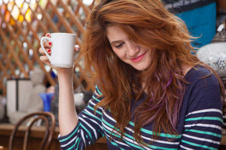 Mid adult woman drinking coffee in restaurantの写真素材