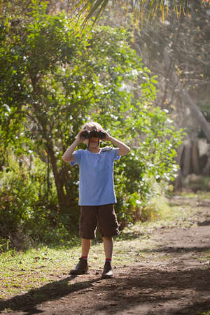 Boy using binoculars outdoorsの写真素材