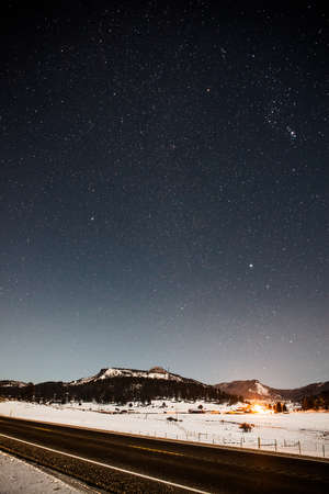 View of highway and snowy mountains at night, Pagosa Springs, Colorado, USAの写真素材