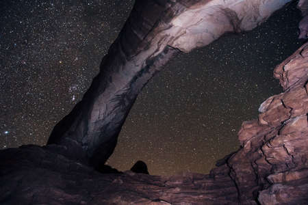 Arch rock formation and starry night sky, Arches National Park, Moab, Utah, USAの写真素材