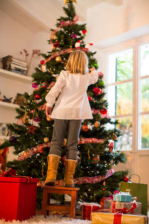 Girl decorating Christmas treeの写真素材