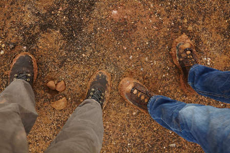 Overhead view of legs standing on gravel roadの写真素材