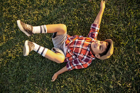 Boy lying on grass playingの写真素材