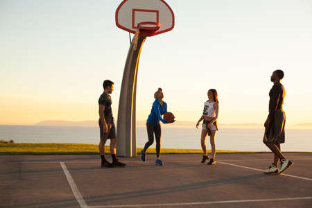 Group of friends playing basketball, outdoors