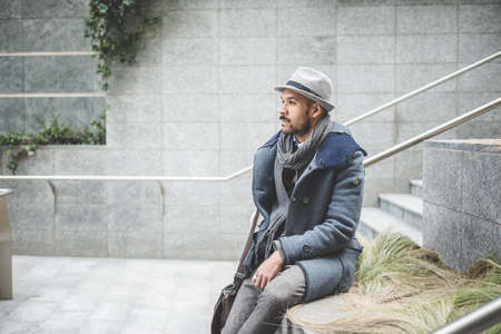 Mid adult businessman sitting on wall