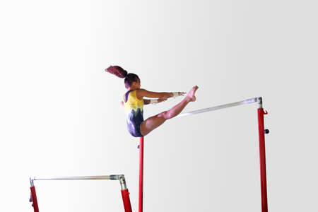 Young gymnast performing on uneven bars