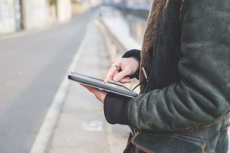 Man using digital tablet by canal, Milan, Italyの写真素材