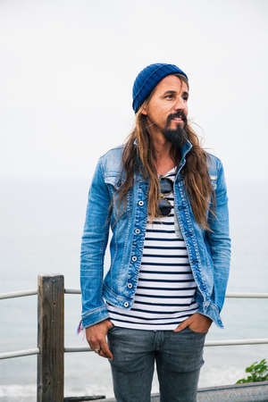 Mid adult man wearing denim jacket and striped top