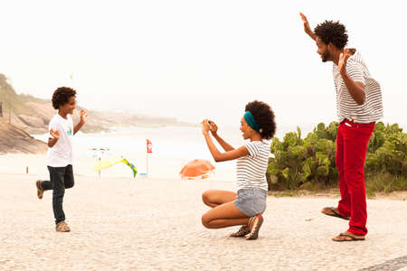 Boy posing for family photograph on Ipanema Beach, Rio De Janeiro, Brazilの写真素材