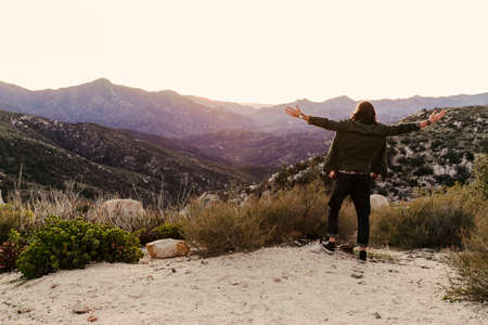 Rear view of young man looking out on landscape, Los Angeles, California, USAの写真素材