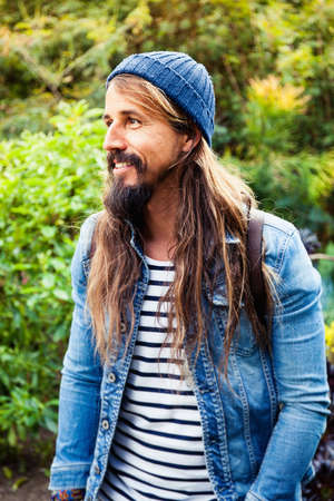 Mid adult man with long hair, wearing hatの写真素材