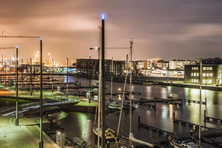 View of waterfront and moored boats at night, Bremerhaven, Germany