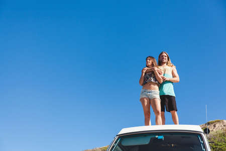 Couple embracing, standing on top of camper vanの写真素材