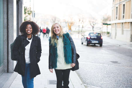 Portrait of two young female friends strolling along street, Como, Italyの写真素材