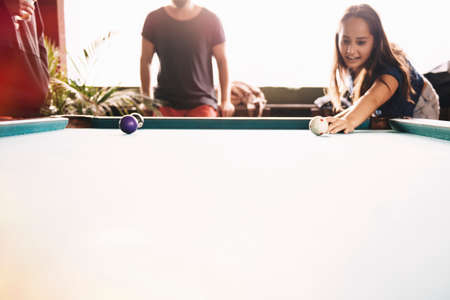 Two young adult friends playing pool,  Lake Atitlan, Guatemala