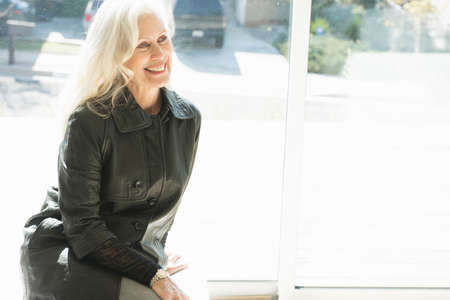 Portrait of a senior woman wearing a leather jacket, smiling