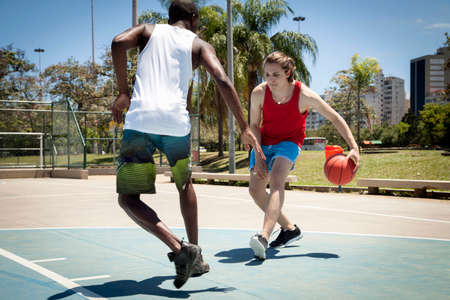Young men practicing basketball on basketball court