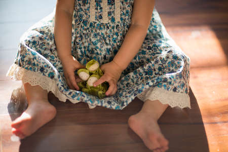 Young girl, sitting on floor, playing with toy, low section