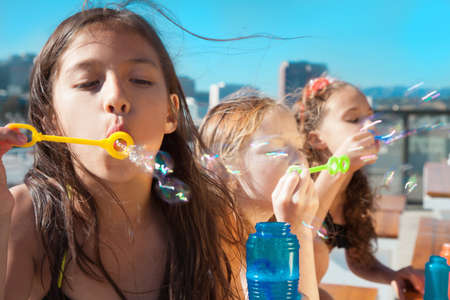 Girls blowing bubblesの写真素材