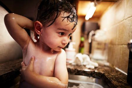 Boy bathing in sinkの写真素材