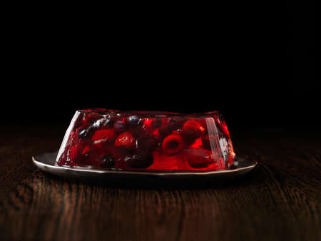 Berry cherry jelly terrine on brown ceramic plateの写真素材