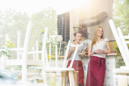 Waitresses taking a break, view through windowの写真素材