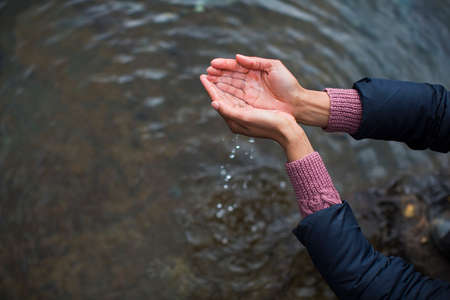 Woman holding water in cupped handsの写真素材
