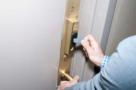 Cropped close up of young man unlocking electronic locked door