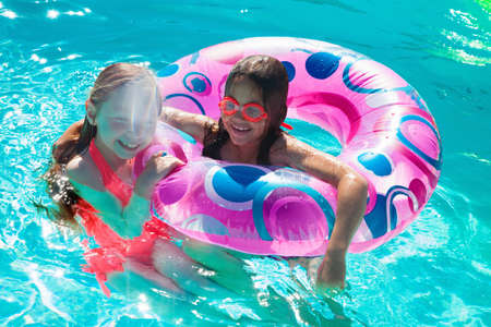 Girls with inflatable ring in swimming pool