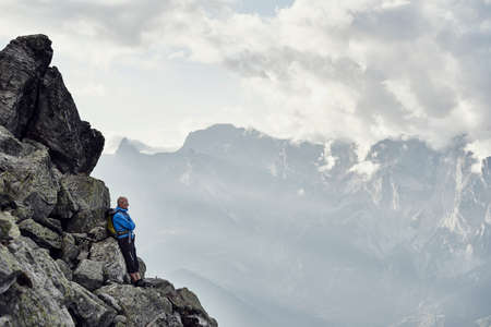 Mature man leaning against rocks, Valais, Switzerlandの写真素材