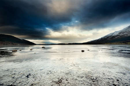 Dramatic sky and ice on Lake Bassenthwaite, Cumbria, UKの写真素材