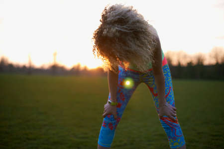 Portrait of woman winding down after exercise in park