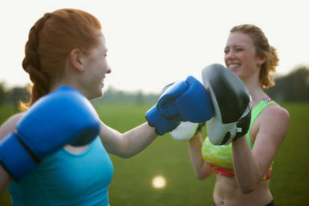 Two women exercising with boxing gloves in the parkの写真素材