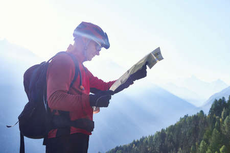 Mountain biker holding map, Valais, Switzerland