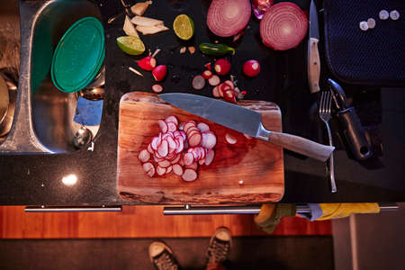 Sliced radish, onion and lime halves, chopping board and knifeの写真素材