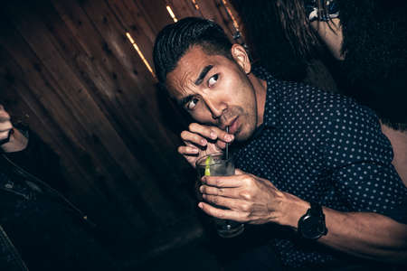 Young man drinking drink in bar